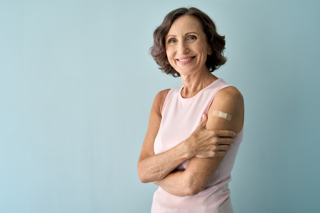 Older adult woman sporting a band-aid signaling her recent immunization.